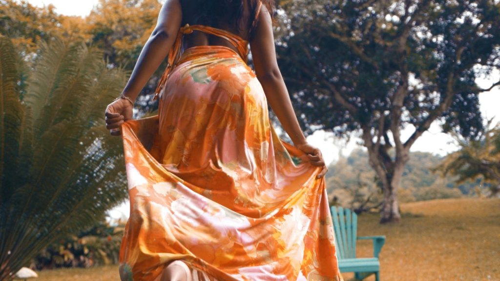 a woman in an orange dress is walking
